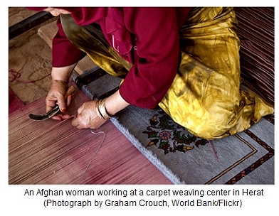 An Afghan woman working at a carpet weaving center in Herat